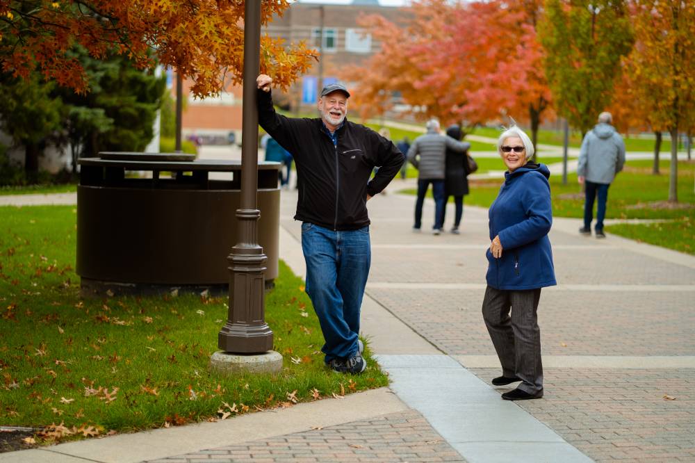 Man and woman enjoy taking their own pictures on campus